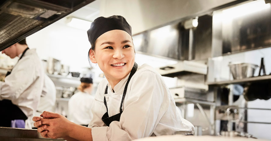 Smiling chef in industrial kitchen