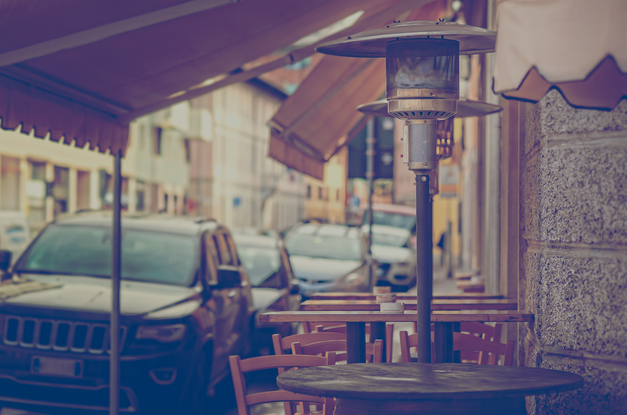 Propane heater on an outdoor patio of a restaurant on a busy street. 