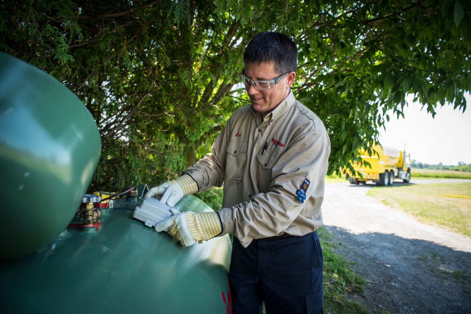 Superior Propane employee installing a smart tank monitor on a residential propane tank. 