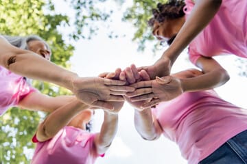 Group of women stacking hands symbolizing teamwork and support