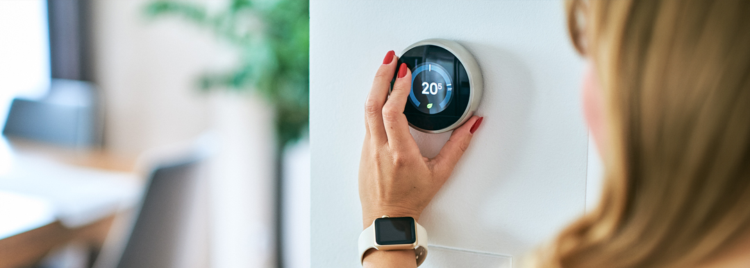 woman checking home thermostat