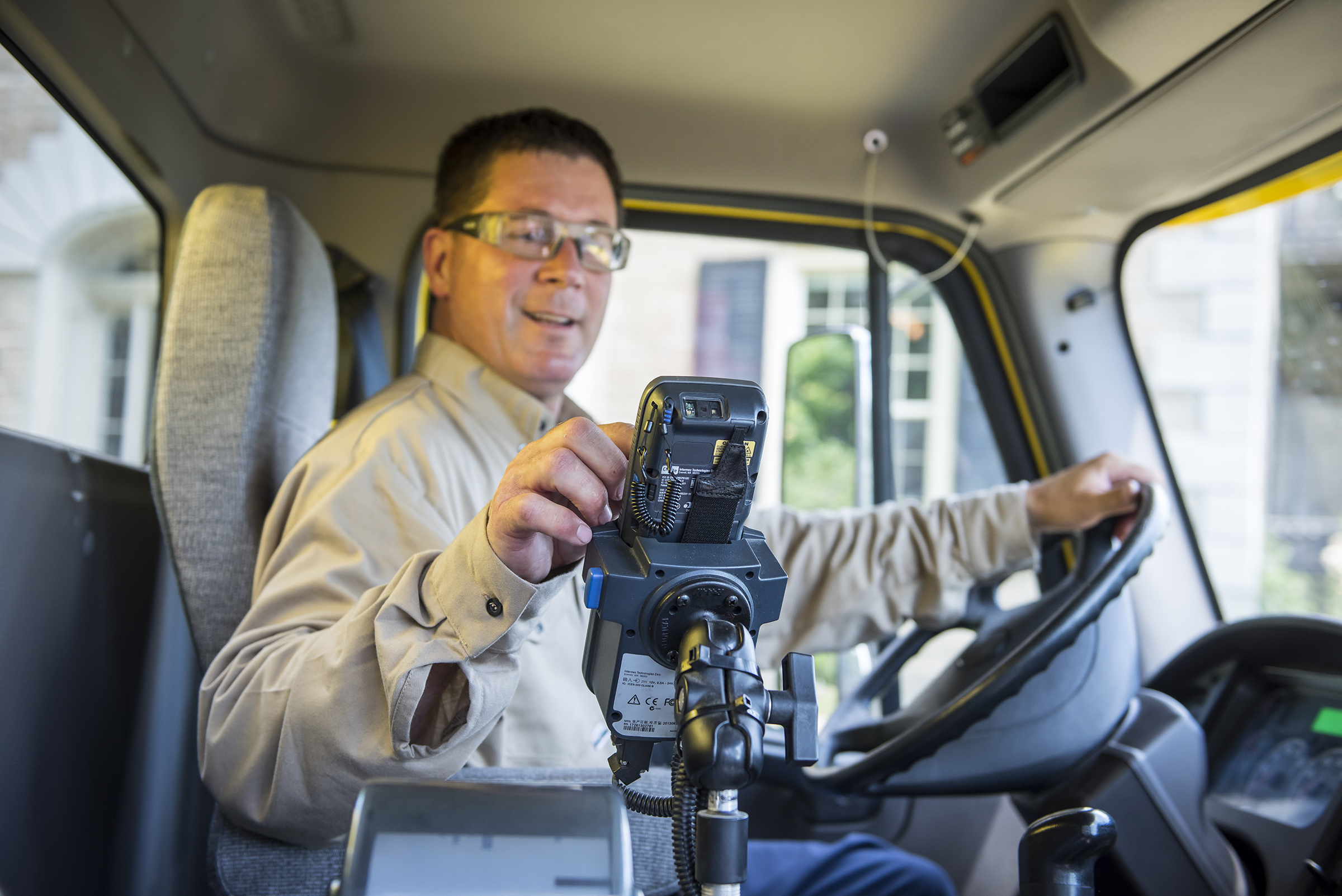 Driver in a truck printing a delivery ticket