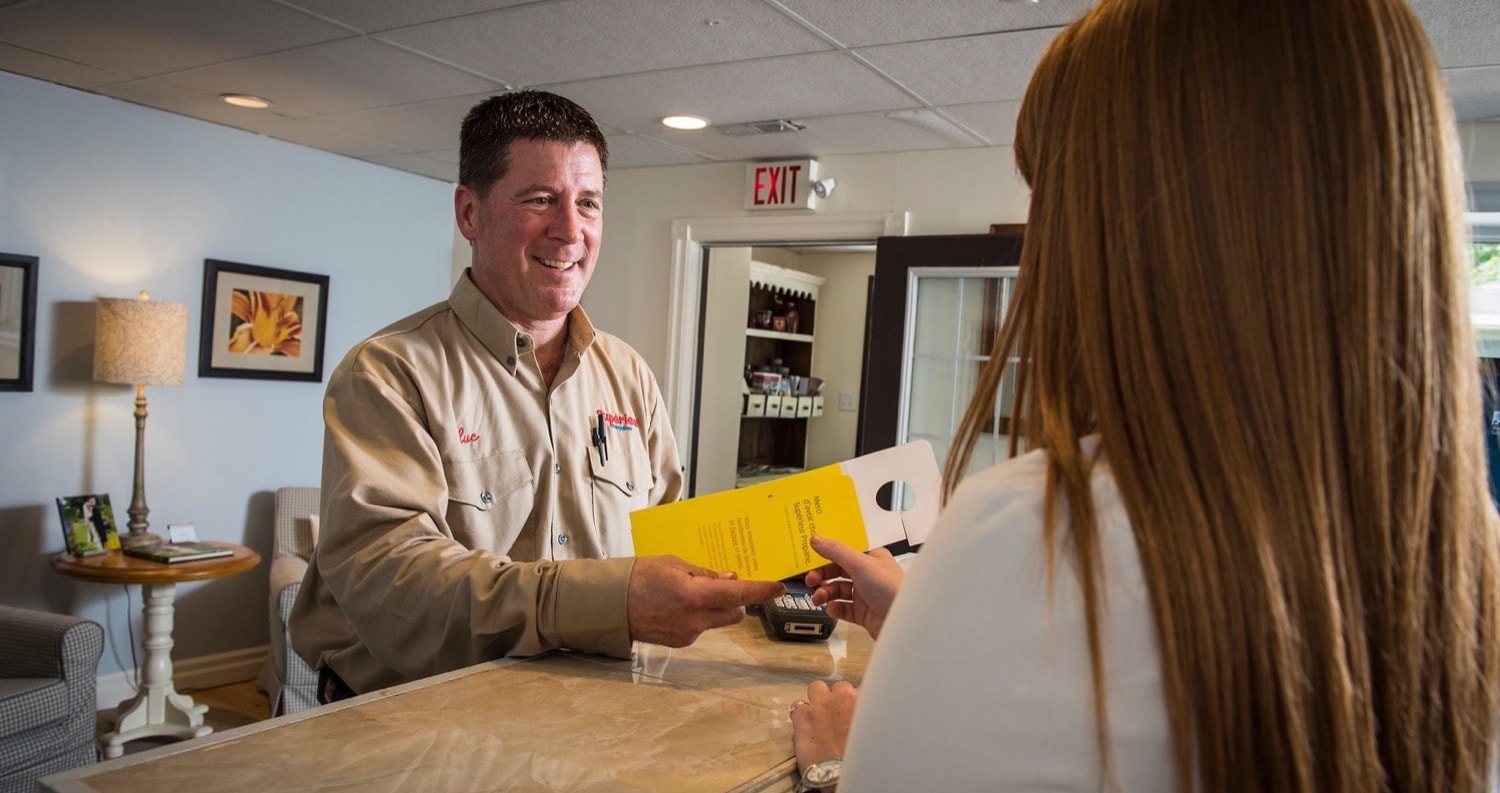 Superior Propane employee handing pamphlet to a residential customer in their home. 