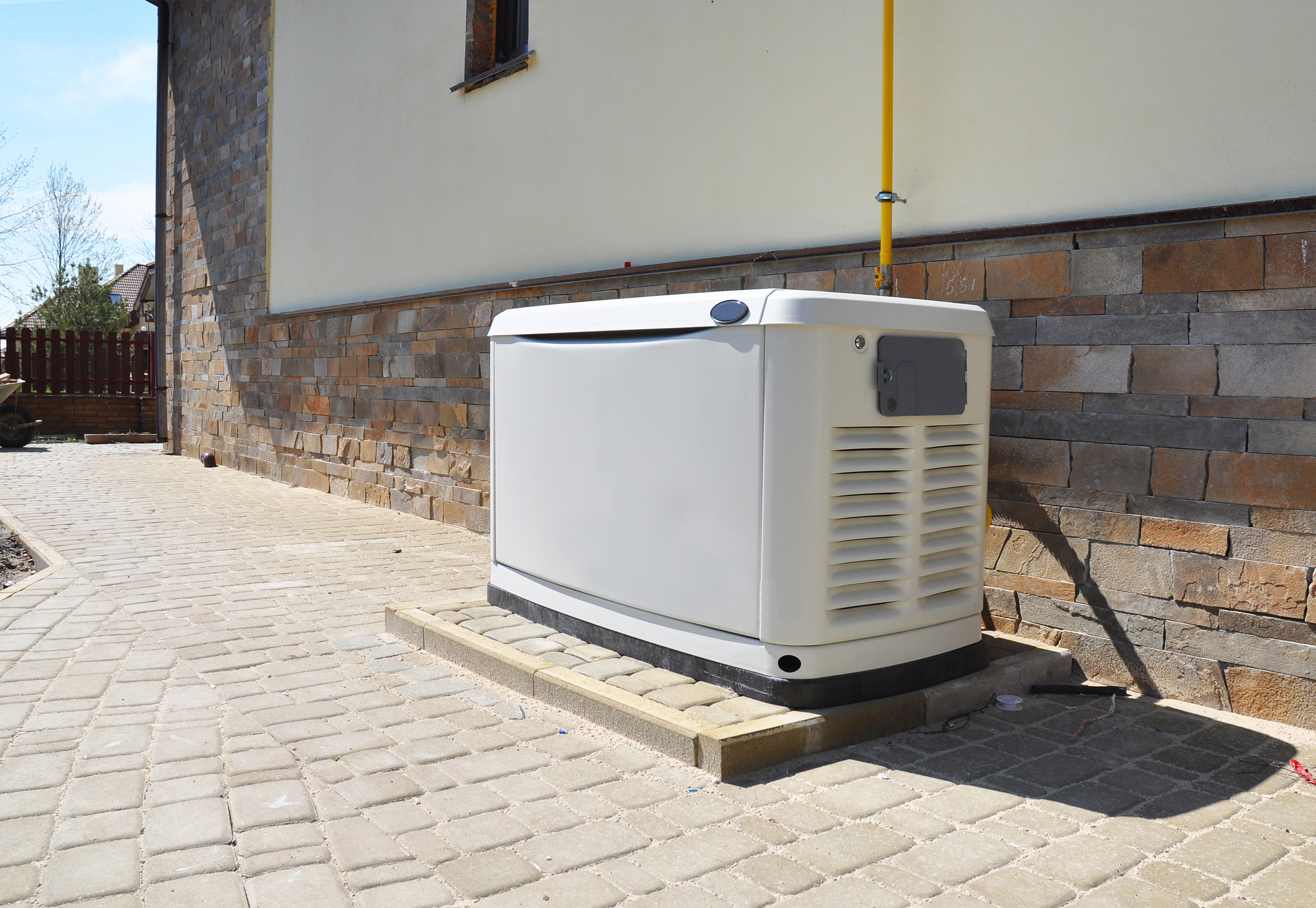 Propane-powered standby generator next to the exterior of a building.  