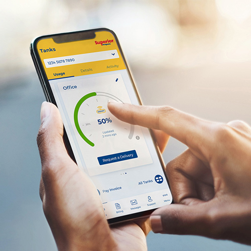 Woman holding cellphone and reading her propane tank level gauge using the mySUPERIOR app. 