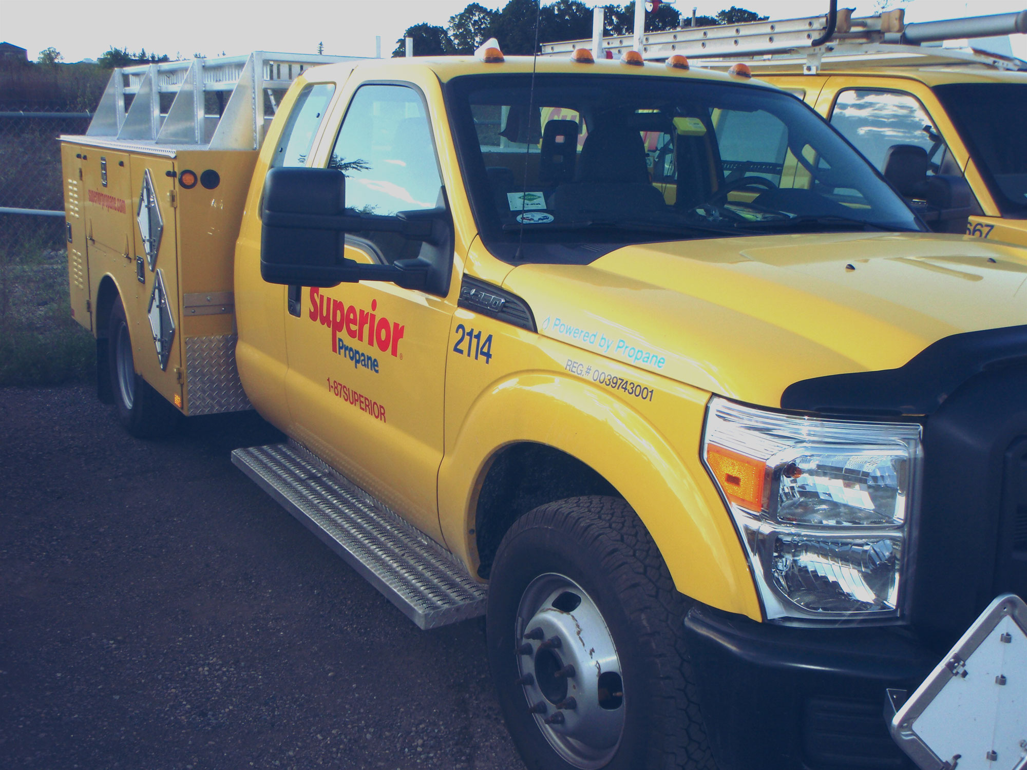 A propane-powered Superior Propane service truck in a parking lot with other Superior Propane vehicles. 