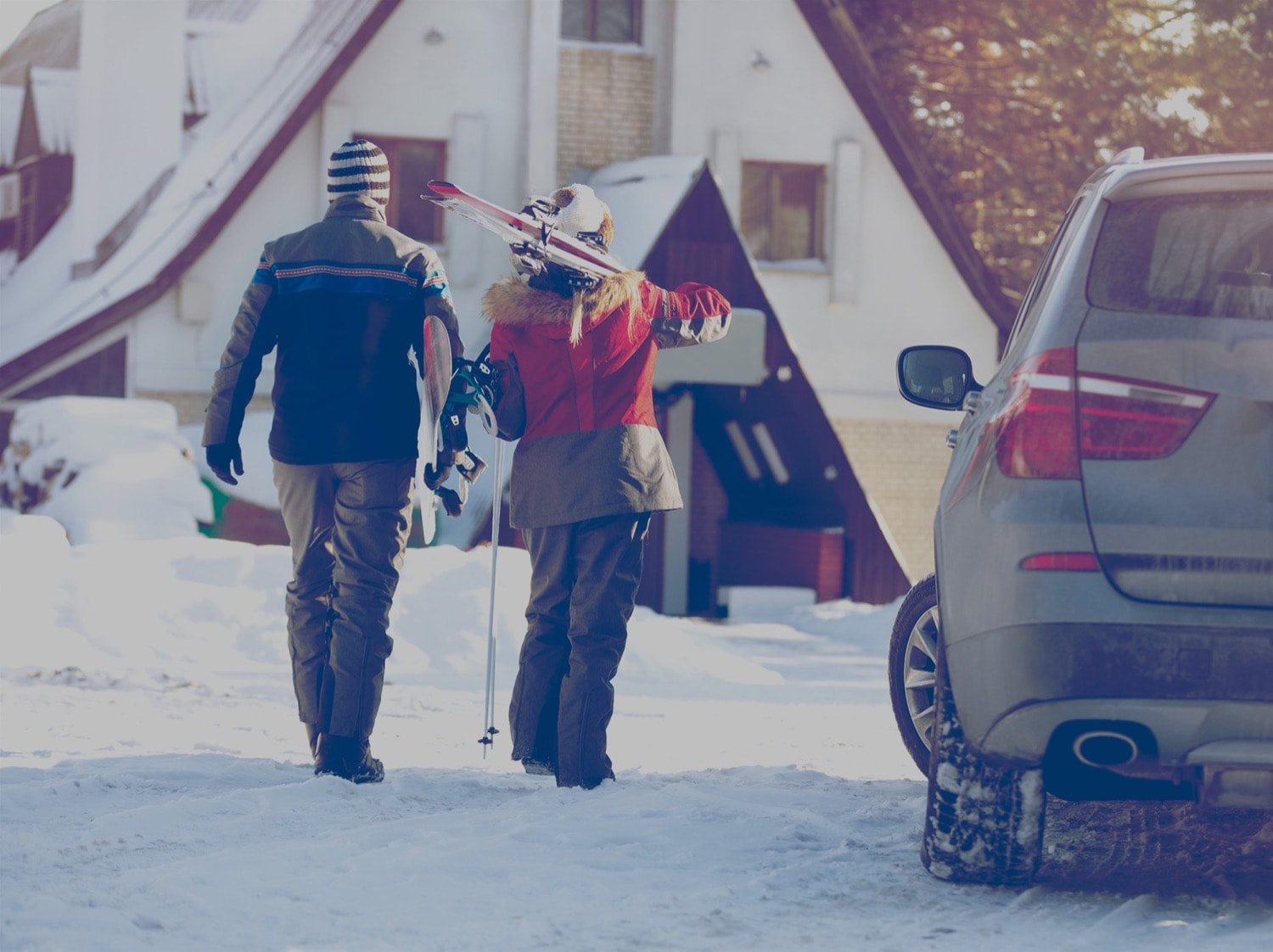 Couple walking into ski resort from the parking lot. 