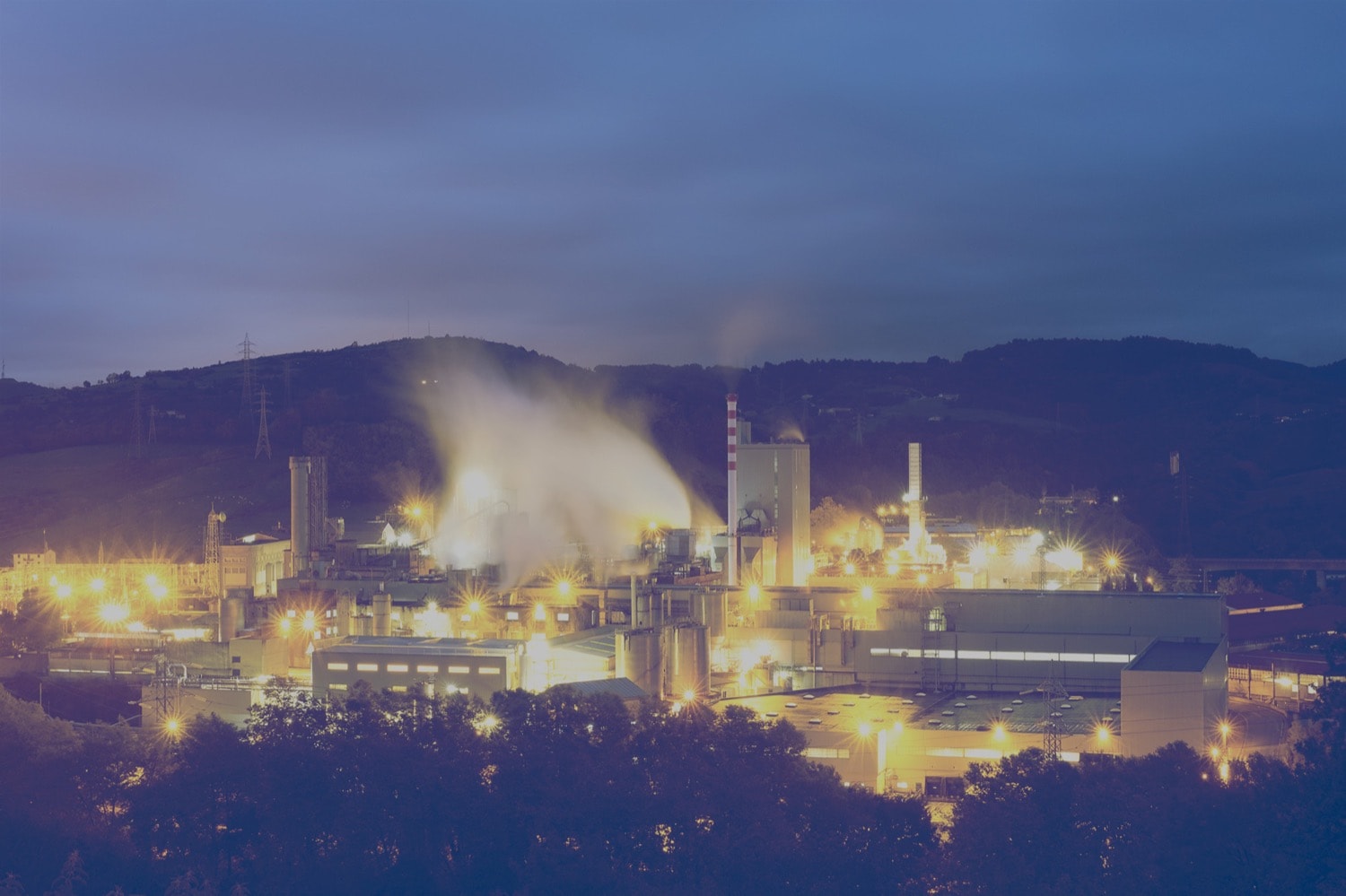 Panoramic view of an oil refinery lit up at night.