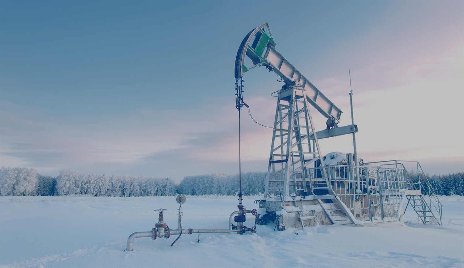 Oil derrick in a field in the middle of winter. 