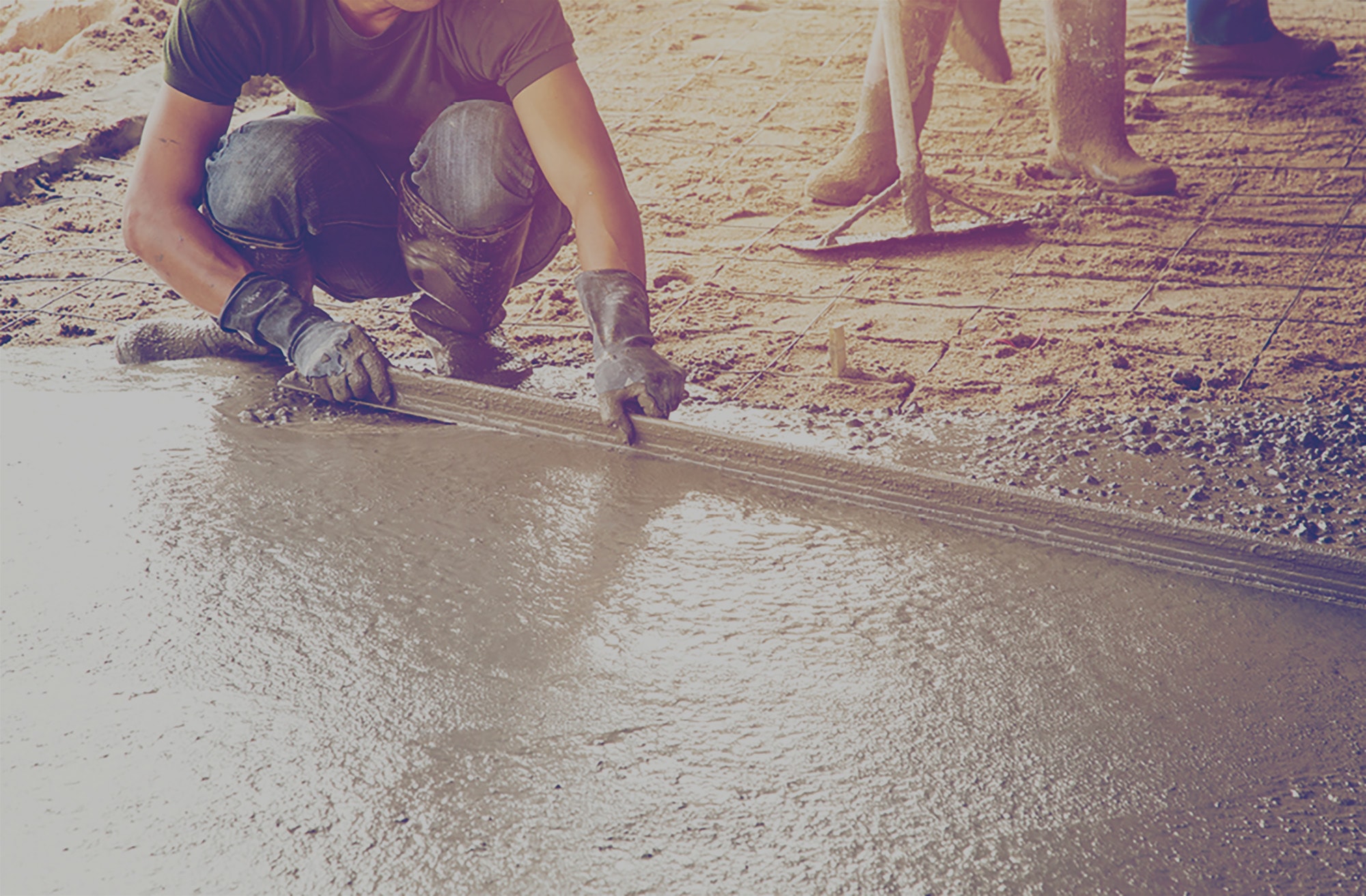 Construction workers preparing poured concrete to be cured using propane. 