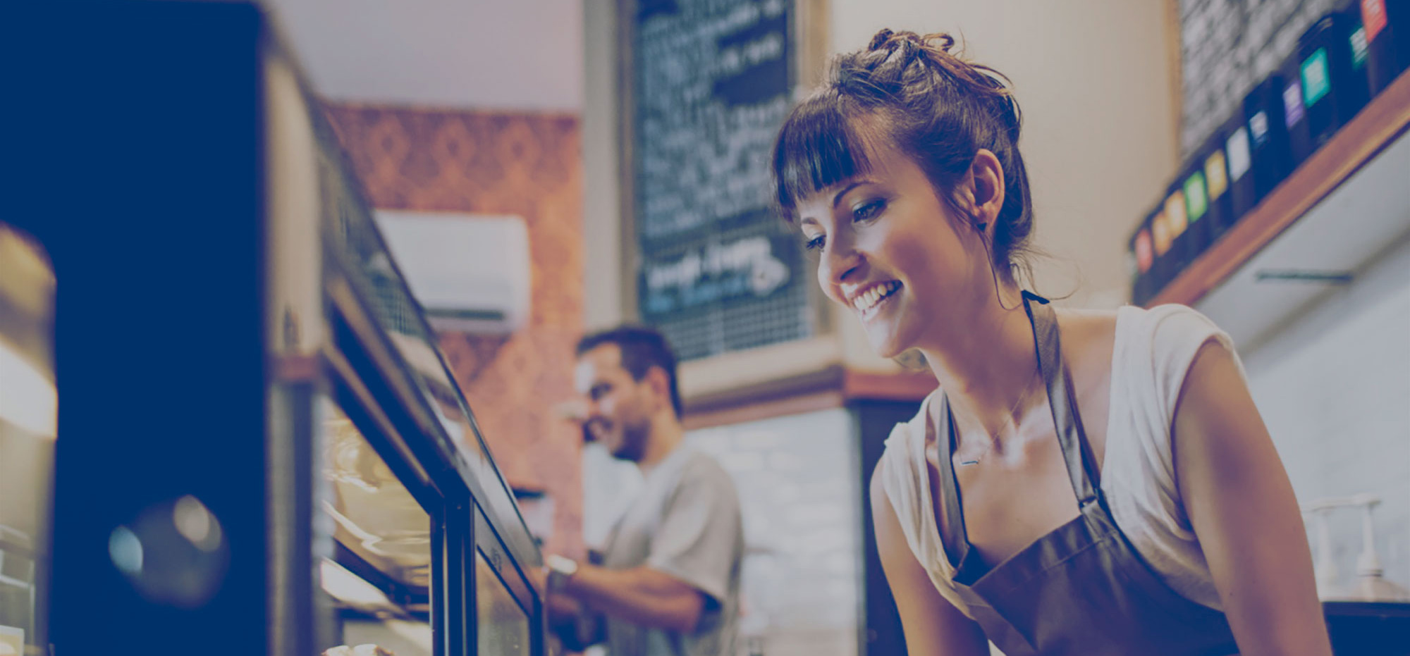 Employé de restaurant prenant un sandwich d'un présentoir réfrigéré. Économies potentielles du propane pour votre entreprise.