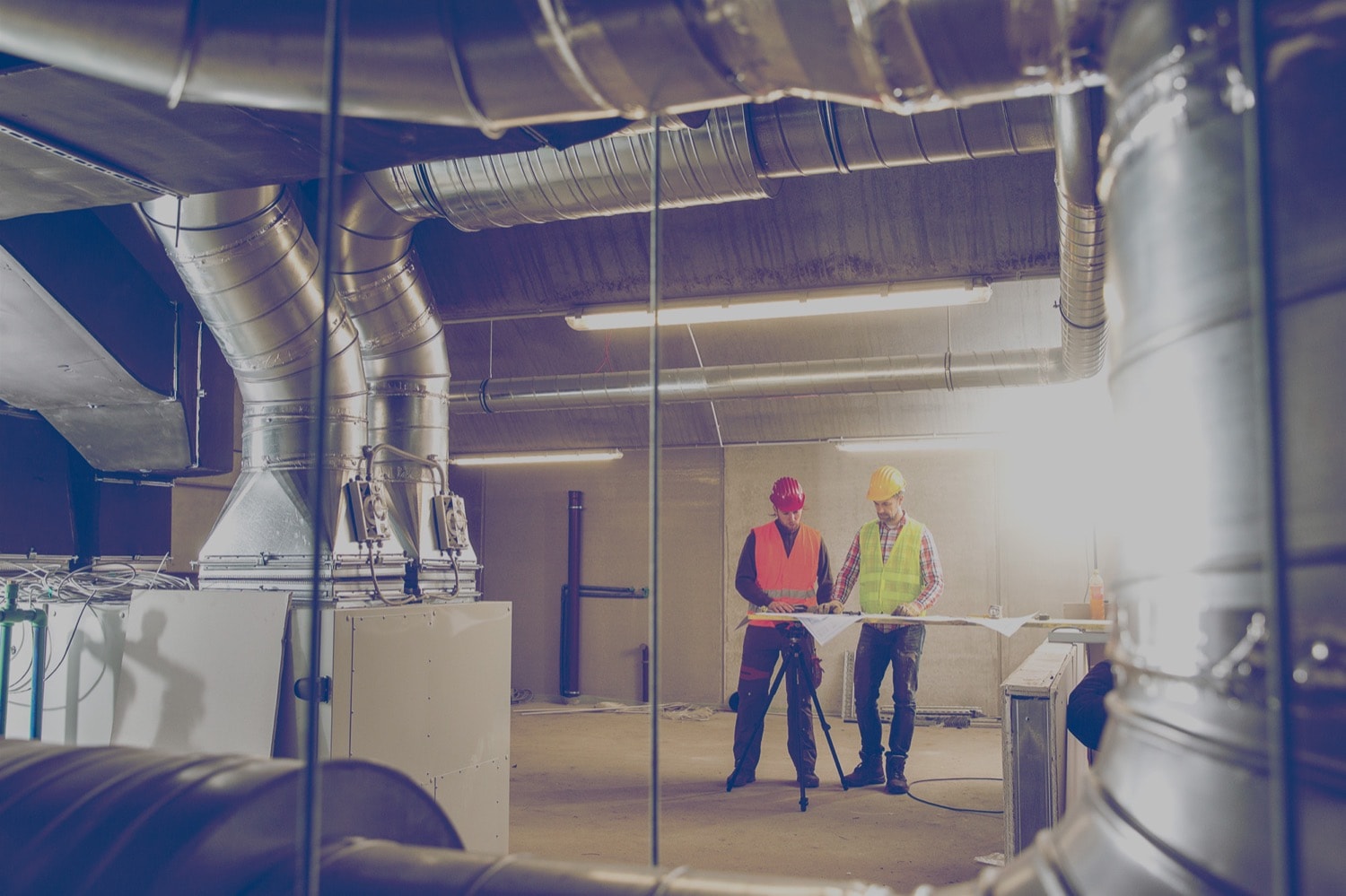 Workers looking at blueprints in an industrial propane furnace room.