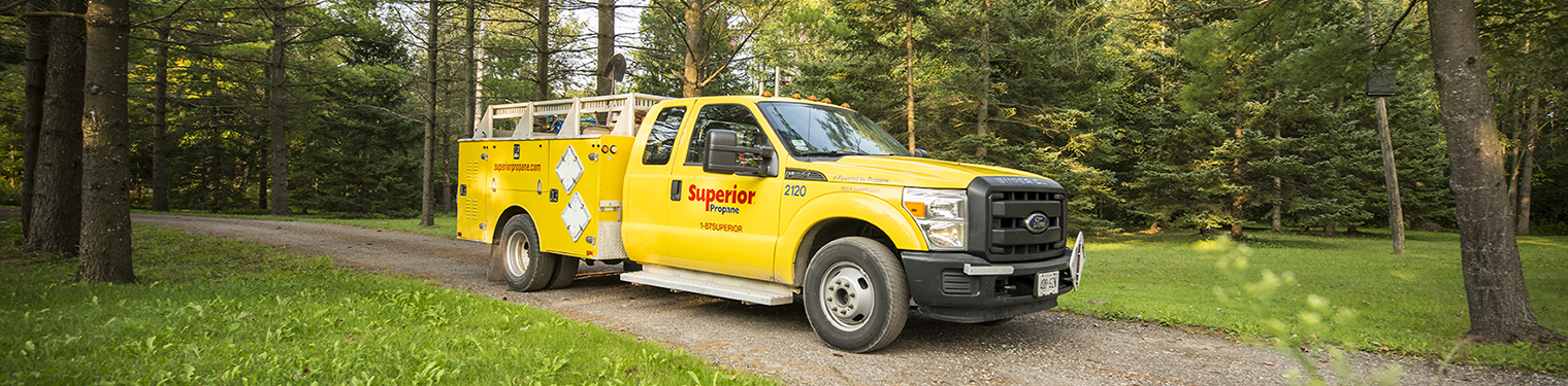 A Superior Propane service truck in motion on a dirt road.