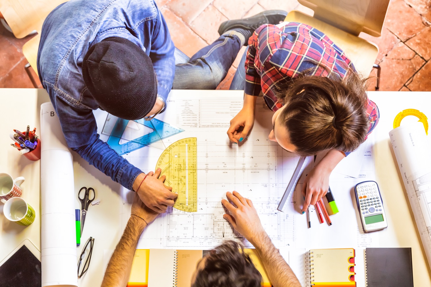 Three people working on the designs of a new home to maximize the uses of propane. 