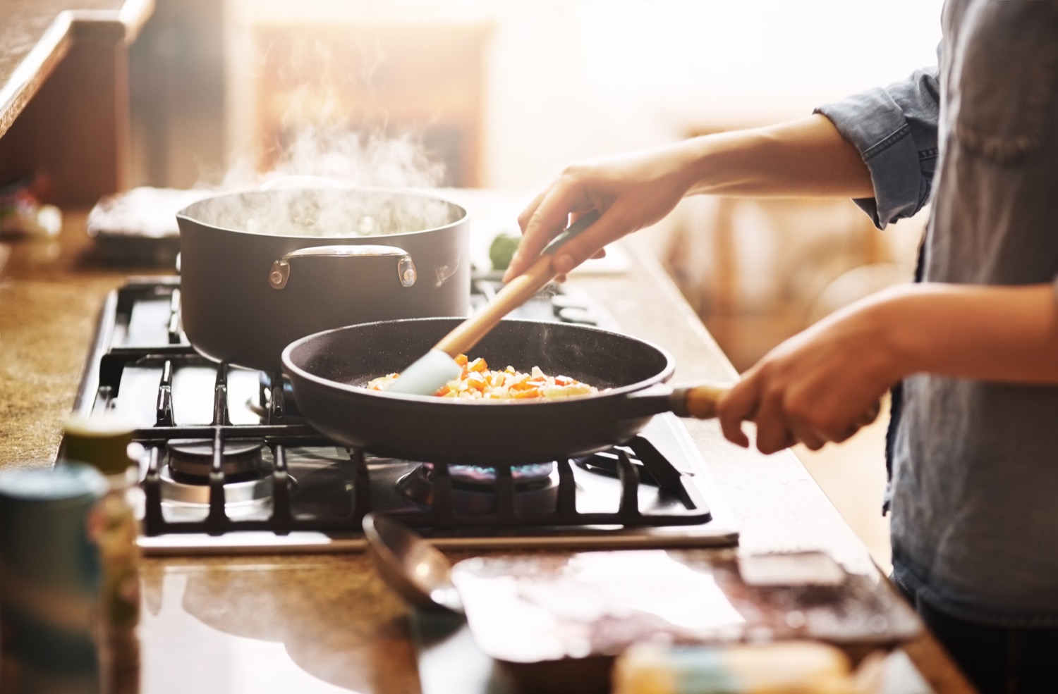 Person preparing food at home on a propane fuelled range. 