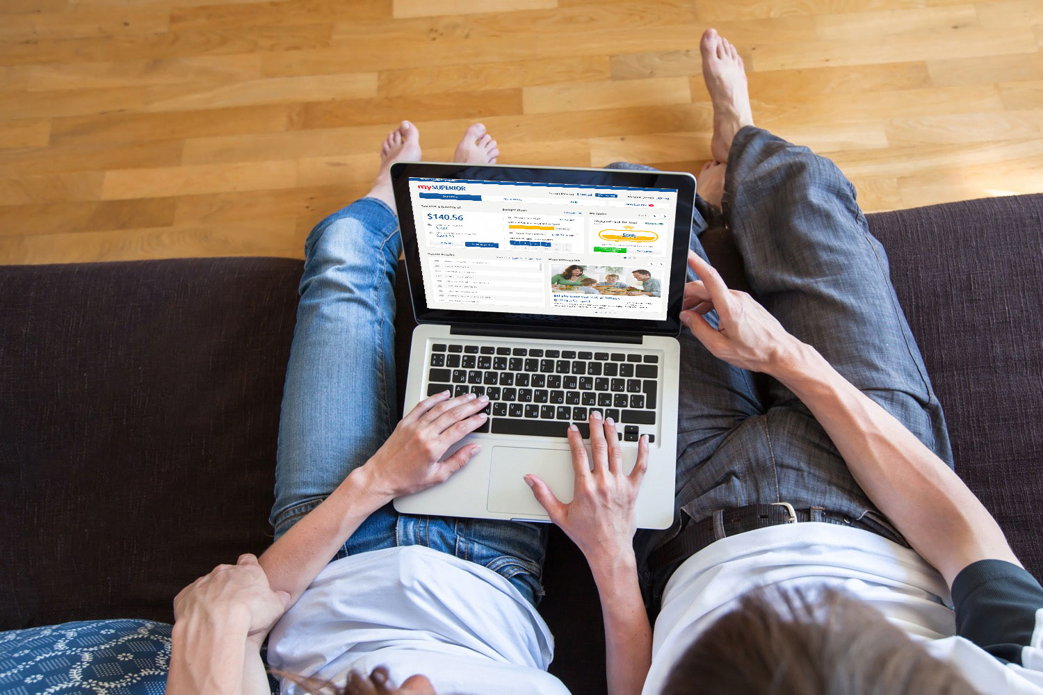 Couple sitting on a couch looking at the mySUPERIOR website on their laptop