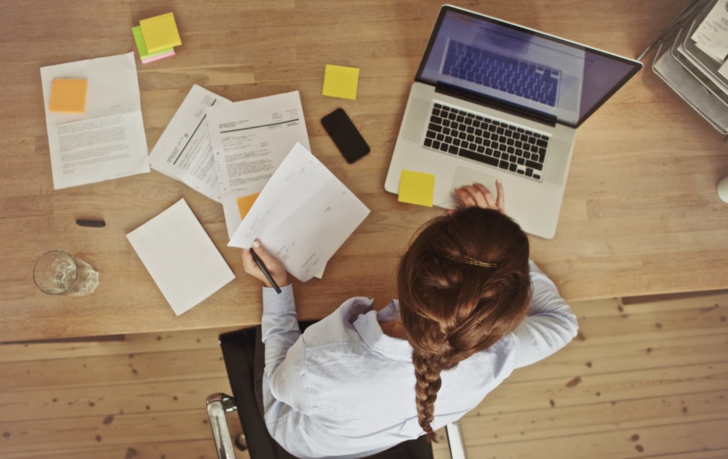 Woman at a desk looking reviewing energy rebate information while working on her laptop. 
