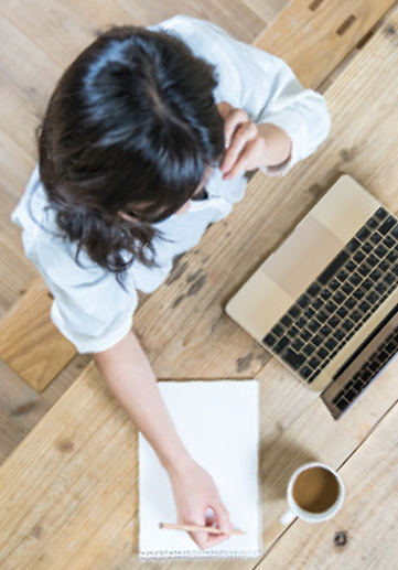 Young woman sitting on a couch paying her Superior Propane bill using a laptop.