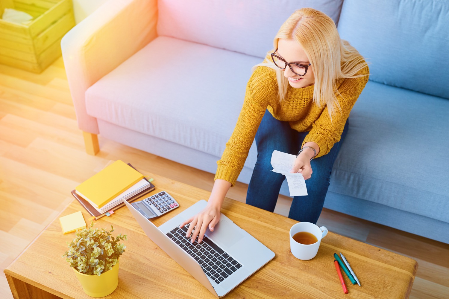 Young woman sitting on a couch paying her Superior Propane bill using a laptop.