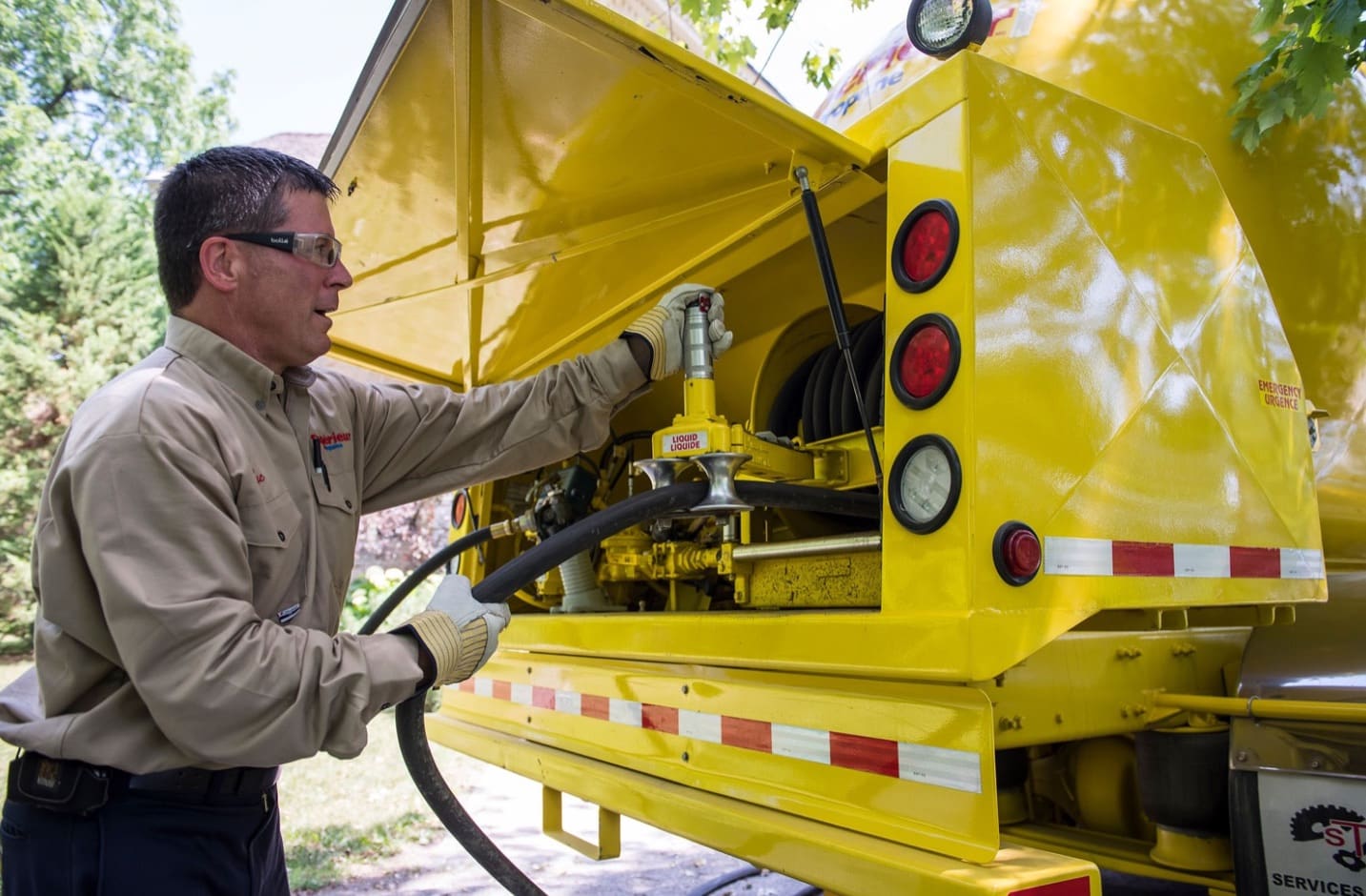 A Superior Propane employee preparing the hose from the truck to start refilling a tank.