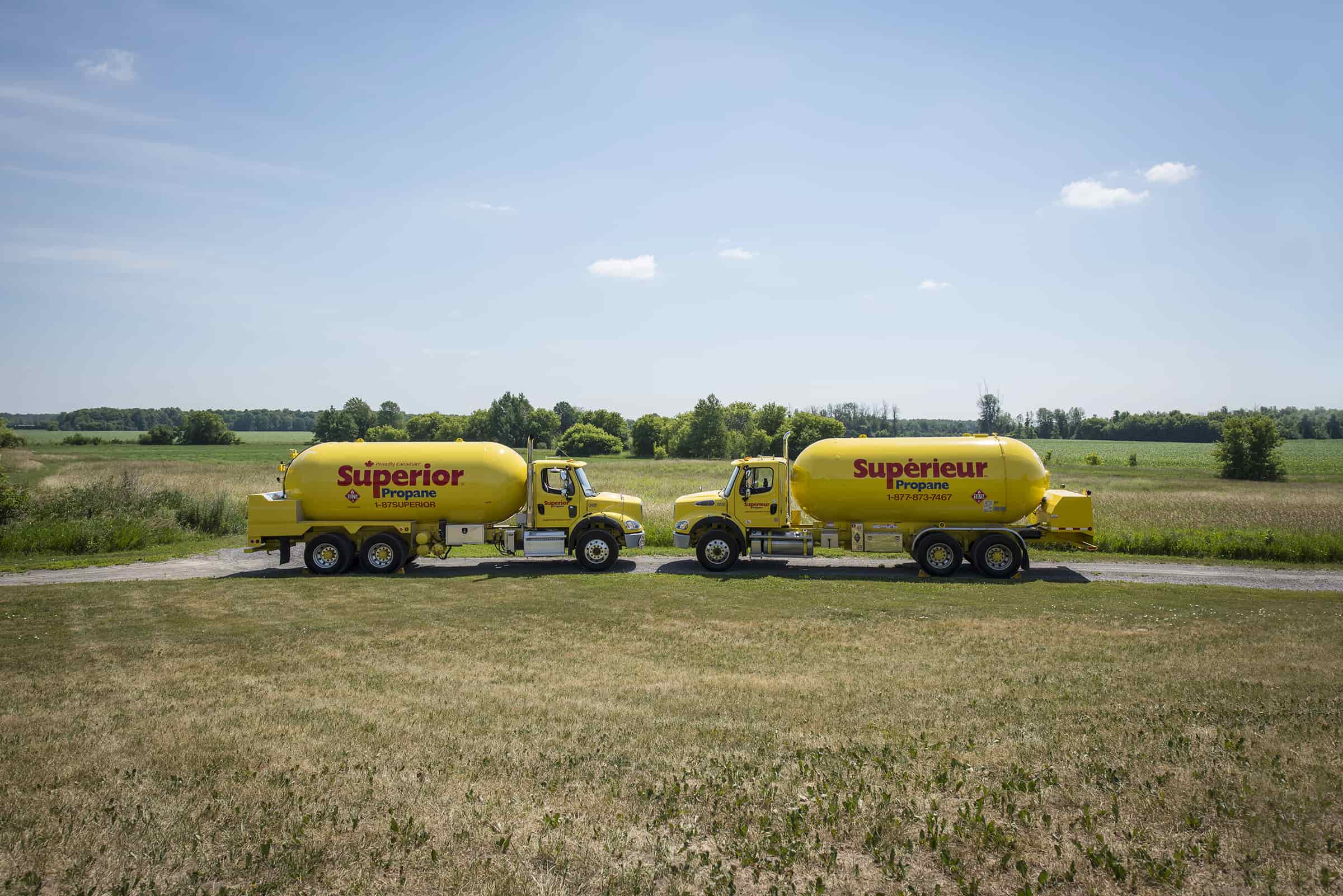 Two yellow Superior Propane trucks parked opposite each other.