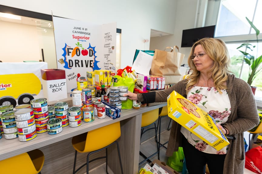 Cambridge Food Bank employee stands next to proceeds from local Superior Propane food drive.