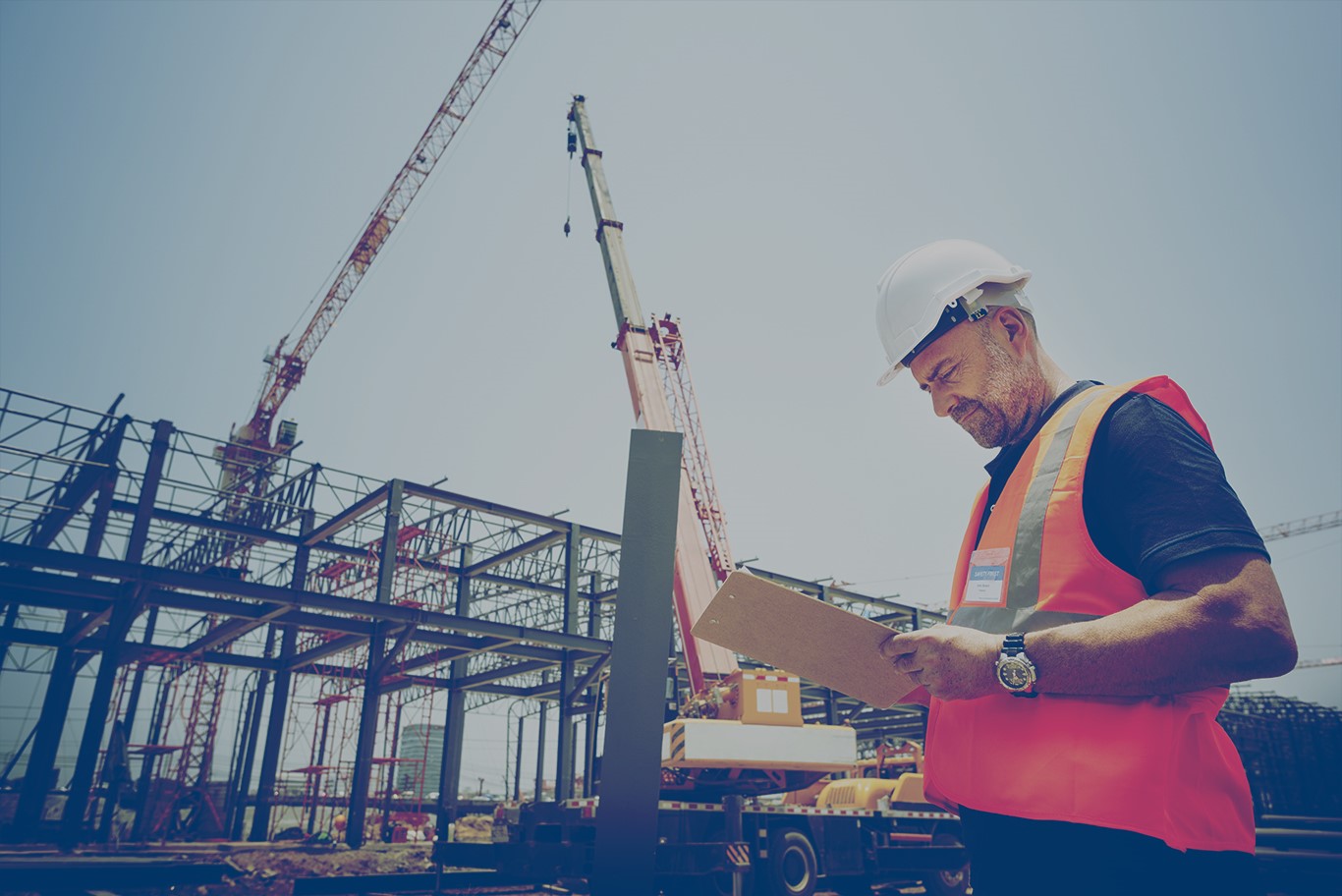 Construction worker looking at a clipboard on a construction site